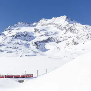 Bernina Express transit along Lago Bianco in winter, Bernina Pass, Engadin