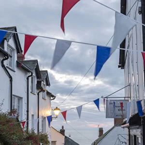 Bunting above the cobbled streets of Clovelly at dawn, North Devon, England. Summer