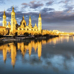 Cathedral of Our Lady of the Pillar reflected in Ebro river at sunrise. Zaragoza, Aragon