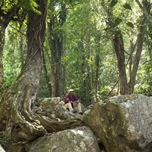 Central America, Belize, Stann Creek, Mayflower Bocawina National Park, a guide sits