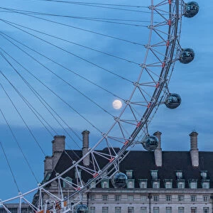 Details of London Eye ferris wheel with County Hall in background under the full moon