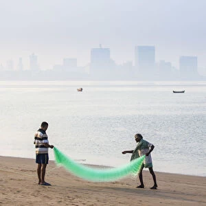 India, Maharashtra, Mumbai, Chowpatty, Men with fishing net on beach