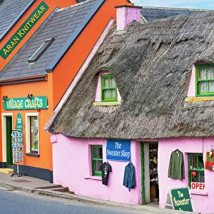 Ireland, Co. Clare, Doolin, colourful street with traditional thatched cottage