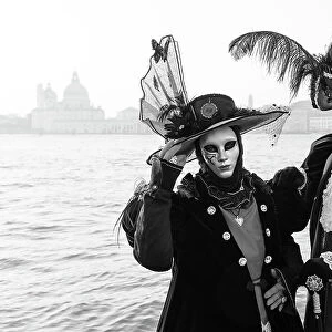 Italy, Veneto, Venice, a black and white version of a couple in costume in front of Salute during the Venice Carnival