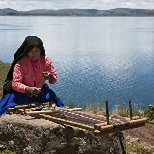 Peru, A Quechua-speaking woman works her traditional wooden loom on Taquile Island