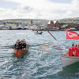 Rowing boats after a competion in occasion of "lavsoka festival in the city of Torshavn. In the background the red buildings of Tinganes. Island of Streymoy. Faroe Islands