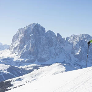 a skier is admiring the winter landscape in Val Gardena, with the Langkofel and Plattkofel