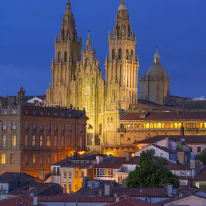 Spain, Galicia, Santiago de Compostela, view over rooftops to cathedral illuminated