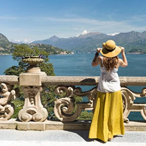Tourist admiring Como lake view from the balcony of villa del Balbianello on punta