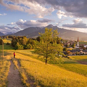 A woman staring at the little village of Vill at sunset with the Saile mountain in the