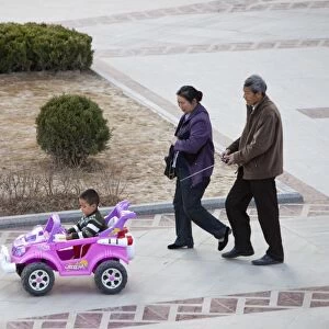 Chinese parents and their child in a remote control car in Inner Mongolia, China