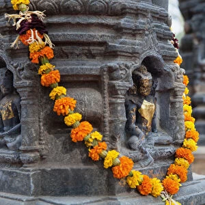 India, Bihar, Bodhgaya, Garland of marigolds wrapped around a stupa at the Mahabodhi Temple in Bodhgaya