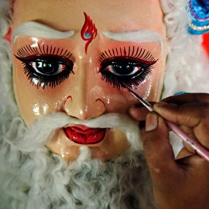 An artisan makes the finishing touches to an idol of Lord Vishwakarma