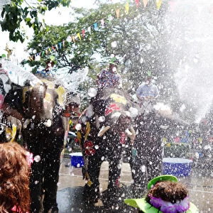 Elephants and people play with water during the celebration of Songkran Water Festival