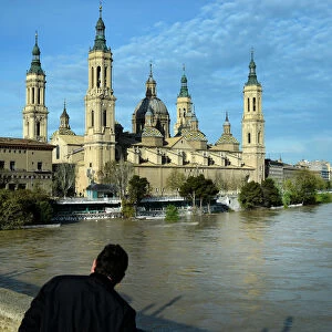 A man observes the River Ebro close to overflowing, following heavy rains and snow melt