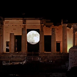 A rising supermoon is seen through the Propylaea, the ancient Acropolis hill gateway