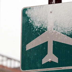 Snow covers a sign marking the route to Logan Airport during a snowstorm in Boston