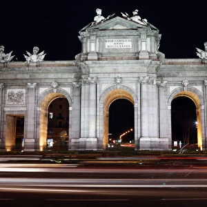 Traffic pass in front of the Alcala Gate, one of Madrids famous landmarks