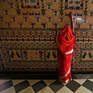A woman prays as she touches the wall of a temple during Navratri festival in Kolkata