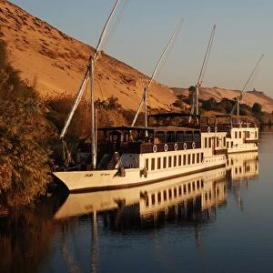 Dahabiya passenger boats moored at riverbank, River Nile, Aswan, Egypt, january