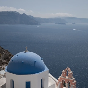 Orthodox church with blue dome, in town on coastal clifftop, Oia, Santorini, Cyclades, Aegean Sea, Greece, September
