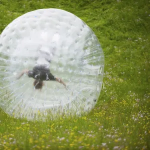 Zorbing, person rolling downhill in transparent plastic orb, Sweden, June