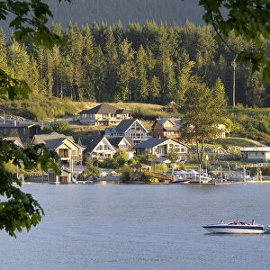 Canada, British Columbia, Cowichan Lake. Ski boat on Cowichan Lake in front of houses