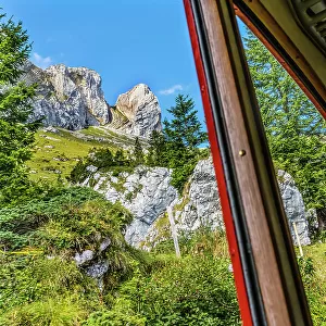 Colorful cogwheel rail car climbing Mount Pilatus, Lucerne, Switzerland