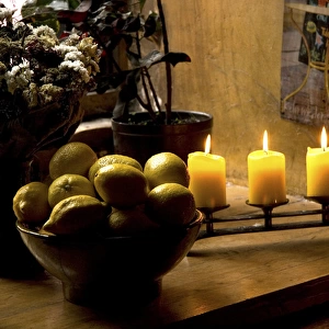 Europe, Estonia, Tallinn. Still life with lighted candles and bowl of lemons inside coffee shop
