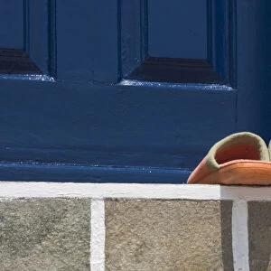 Europe, Greece, Mykonos, Hora. Orange slippers on threshold of blue door. Credit as