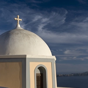 Greece, Santorini. Church dome against clouds and blue sky with Aegean Sea in background