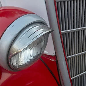 Detail of head light and grill on red classic American Ford in Habana, Havana, Cuba