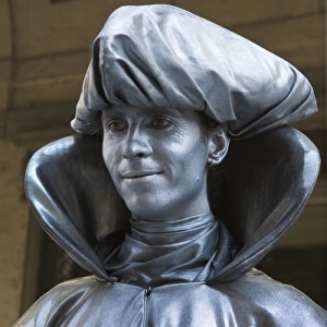 Italy, Florence. A mime in silver paint stands for a portrait