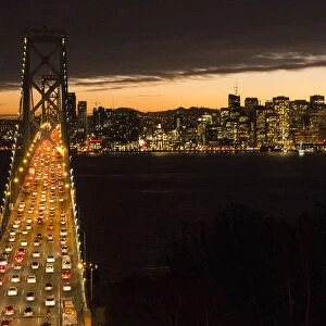 San Francisco California skyline and the Oakland Bay Bridge at evening with traffic on bridge