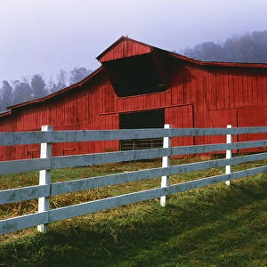USA, Virginia, Scott County. Red barn and white fence on farm. Credit as: Dennis