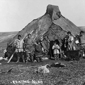 ALASKA: ESKIMO IGLOO. A group of Eskimos standing in front of their igloo in Alaska