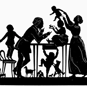 CUTTING SILHOUETTES. A family cutting silhouettes with scissors