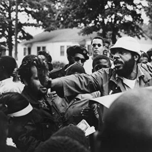 DICK GREGORY (1932- ). American comedian, clearing through a crowd before speaking at Liberty Park in Norfolk, Virginia, while campaigning for president on the Peace and Freedom Party ticket, 18 October 1968