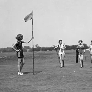 GOLFING, 1926. Women wearing bathing suits on a golf course. Photograph, 1926