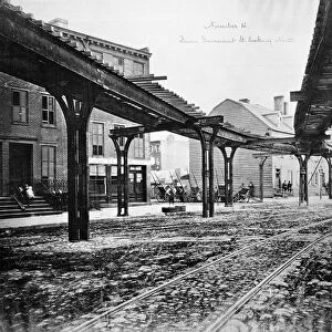 NEW YORK: NINTH AVENUE. View looking north from Gansevoort Street of the intersection at Little West 12th Street where Greenwich Street turns into Ninth Avenue, with tracks of the Greenwich Street-Ninth Avenue elevated railroad line running overhead. Photographed in 1876