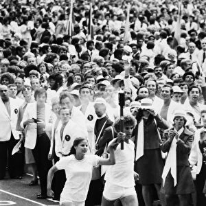 OLYMPIC GAMES, 1976. Torch bearers Sandra Henderson (age 16) and Stephane Prefontaine (age 15) on their way to light the Olympic flame at the opening ceremonies of the Summer Olympic Games in Montreal, Quebec, Canada, 17 July 1976