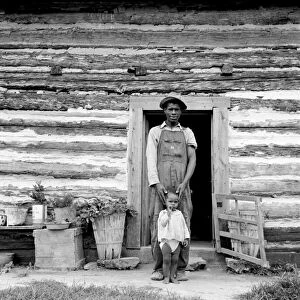 SHARECROPPER, 1939. A young African American sharecropper and his first child standing