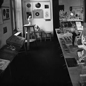 Tactile charts on the table in the foreground and a modelling studio with color charts at left at the New Bauhaus in Chicago, Illinois. Photograph, c1940