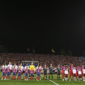 The Arsenal and Steau teams line up before the match