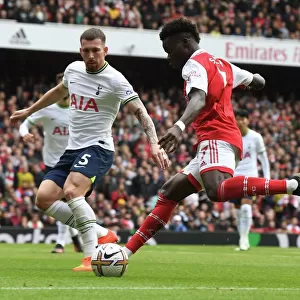 Arsenal's Bukayo Saka Outmaneuvers Tottenham's Pierre-Emile Hojbjerg in the 2022-23 Premier League Clash