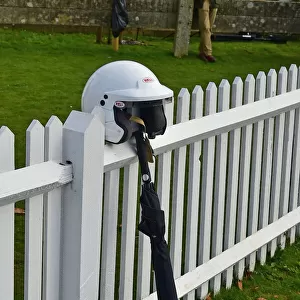 CM32 0366 Racing helmet and umbrella against the fence