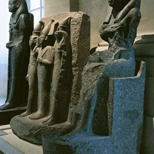Ancient Egyptian statues representing Isis breast-feeding triad of pharao among Osiris, Horus and Nephthys