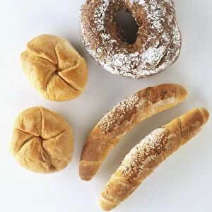 Austrian breads, including white bread buns (Kaisersemmel), bread sticks (Salzstangerl) and a rye bun with a hole in middle, view from above