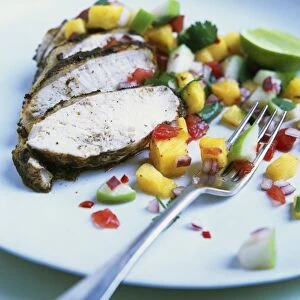 Barbecue jerk chicken with spicy pineapple and apple salsa on plate, with fork