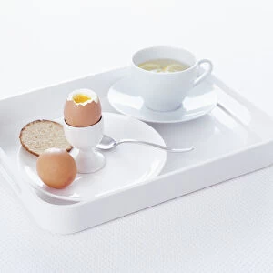 Boiled egg, cracker and cup of tea on serving tray